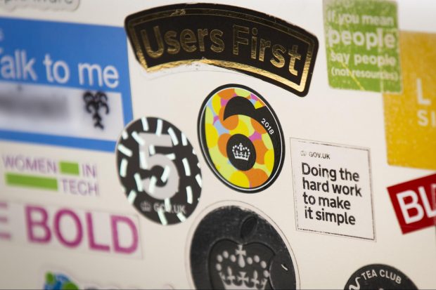 A laptop covered in stickers, including one that reads 'GOV.UK 6'