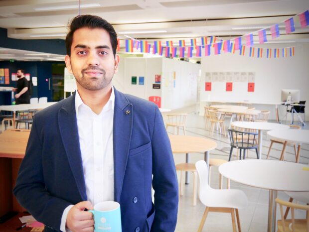 Bharath Vadhoola at the Government Digital Service offices holding a blue mug 