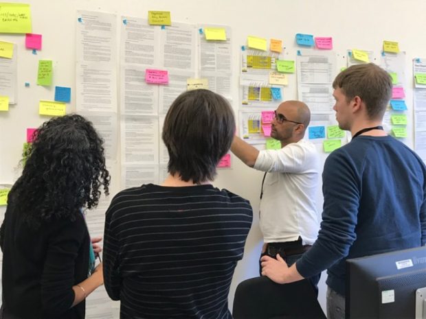 Members of the Race Disparity Unit viewing notes on a wallchart