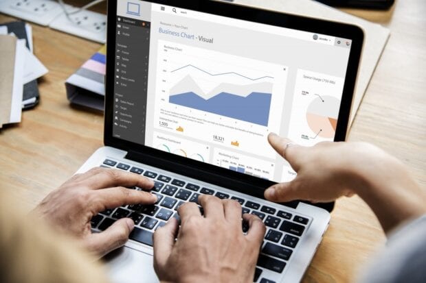 Two people working on a dashboard on a laptop