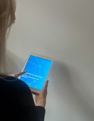 A person holding a tablet which has a blue screen and a cool network effect displayed.